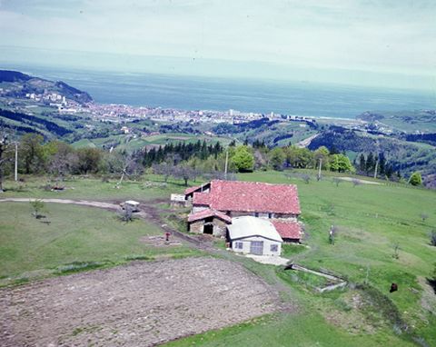 Vista aérea de un caserio de Zarautz con el pueblo al fondo.