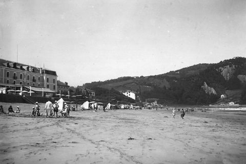 Bañistas en la playa de Zarautz y fachada del Gran Hotel de Zarautz en el malecón