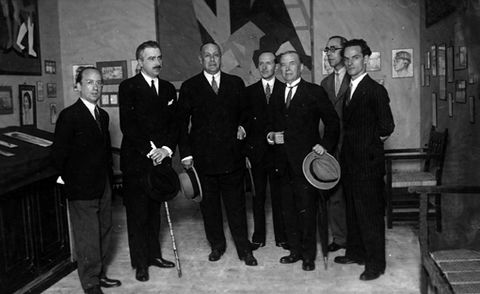 Fotografía de un grupo de hombres en la visita a una exposición de pintura