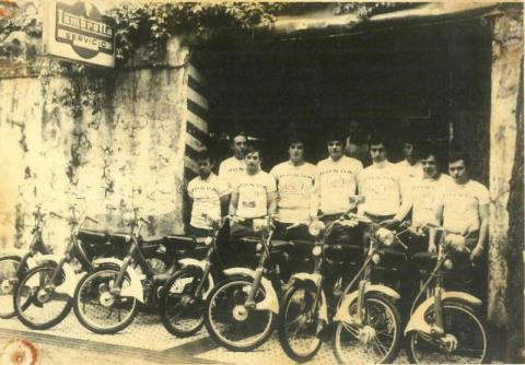 Motoristas en la entrada del taller de bicicletas de Eusebio Bastida